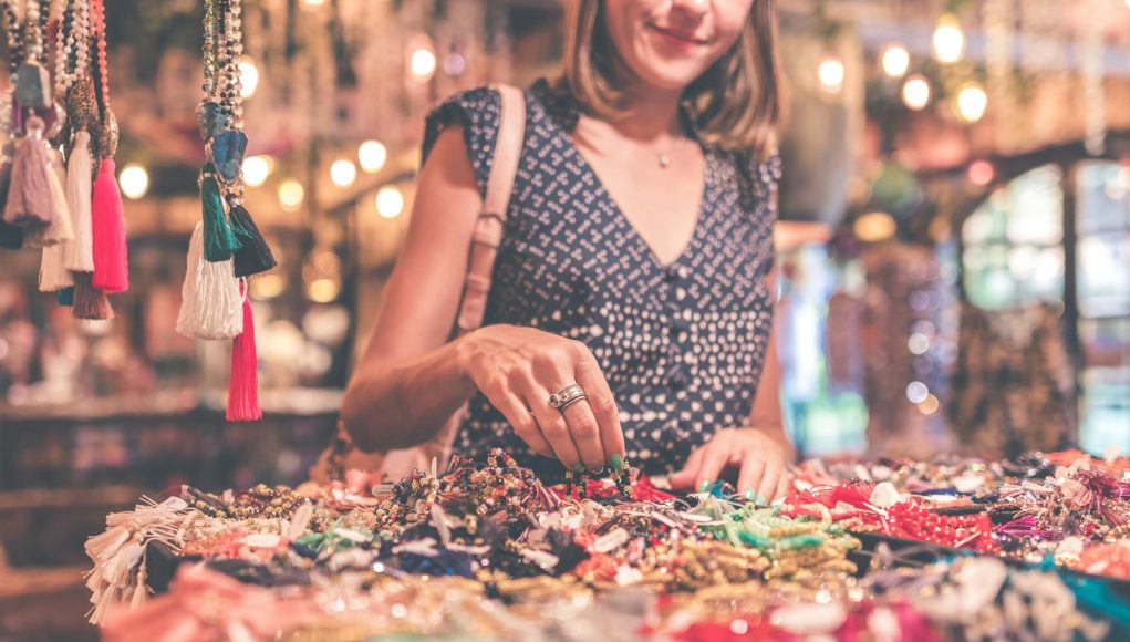 woman standing beside table of accessories