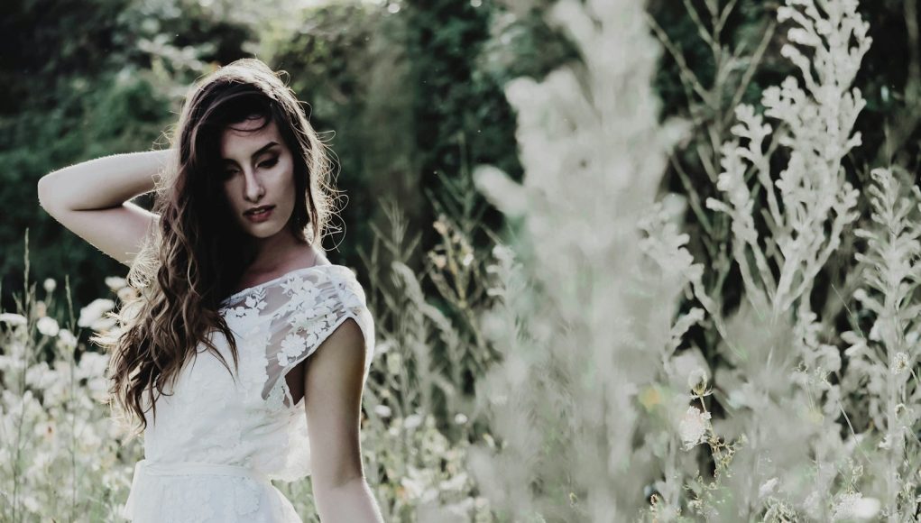 selective-focus photography of woman standing in a white flower field during daytime