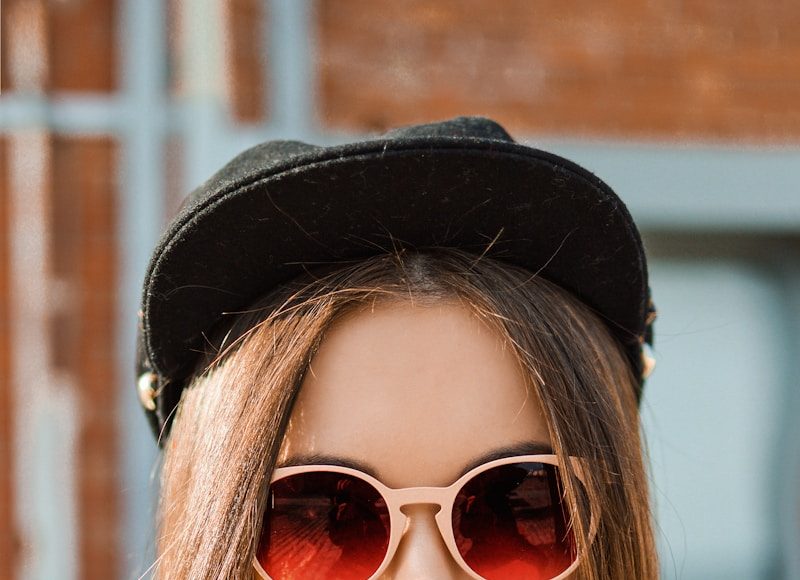 woman in white knit sweater and black fitted cap