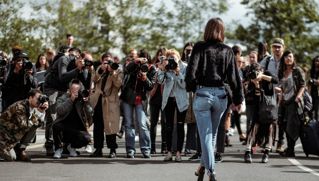 woman walking taking photo by people